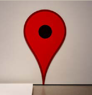 Rote Skulptur in Form eines Standortzeichens mit schwarzem Mittelpunkt.