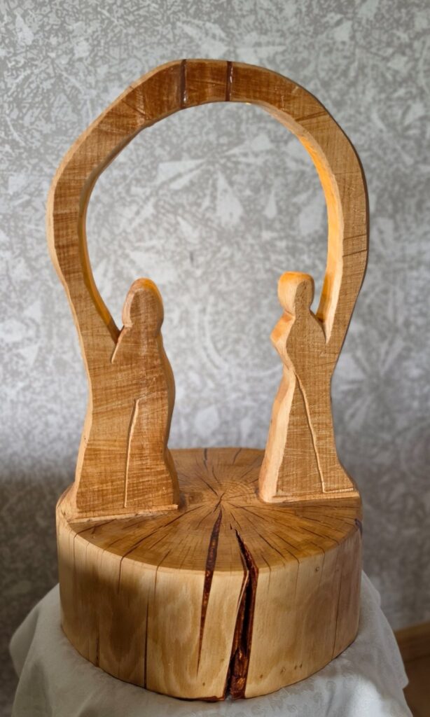 Holzskulptur mit zwei Personen im Gespräch – Sinnbild für Coaching, Mediation und Begegnung bei decira.